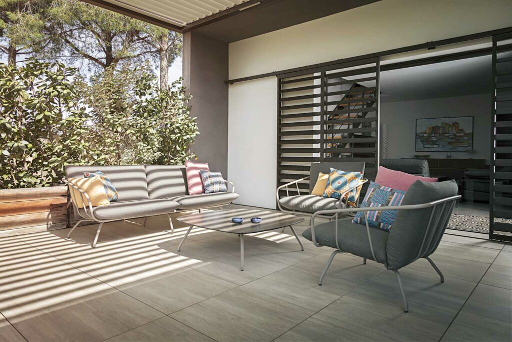 Terrasse couverte avec pergola et volets motorisés horizontaux, mobilier d'extérieur contemporain, ombre naturelle ajustable