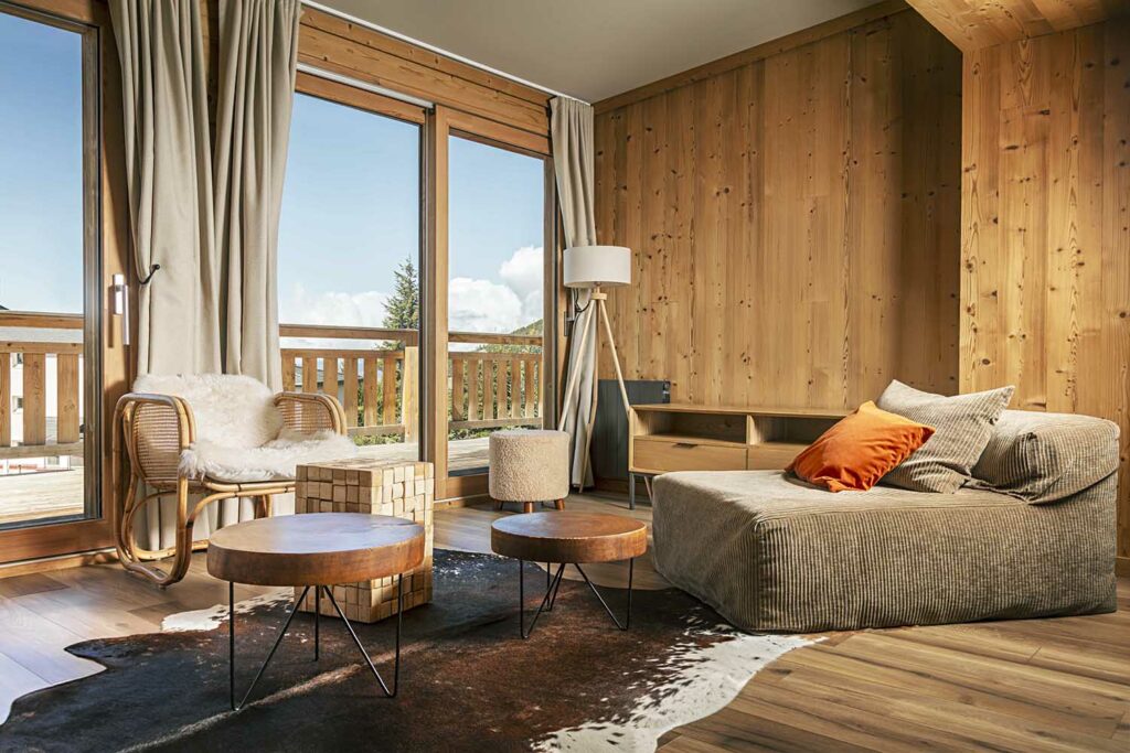 Baie vitrée coulissante bois chalet, balcon terrasse, rideaux beige lin, vue campagne