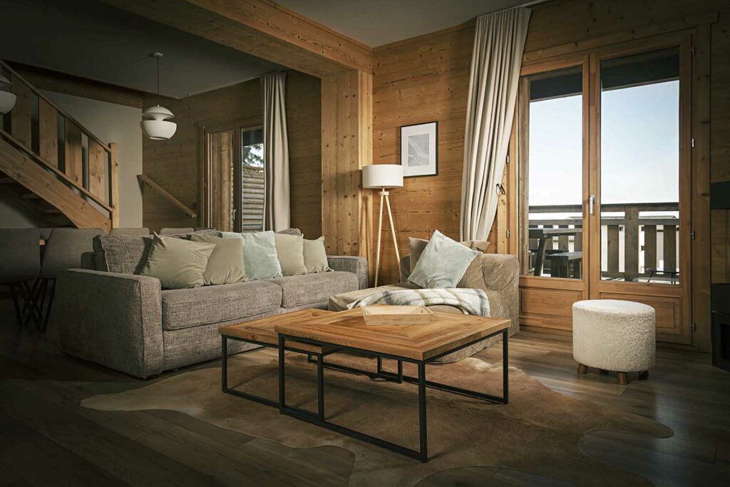 Porte-fenêtre arquée bois massif, intérieur chalet naturel, chaises rotin, accès extérieur