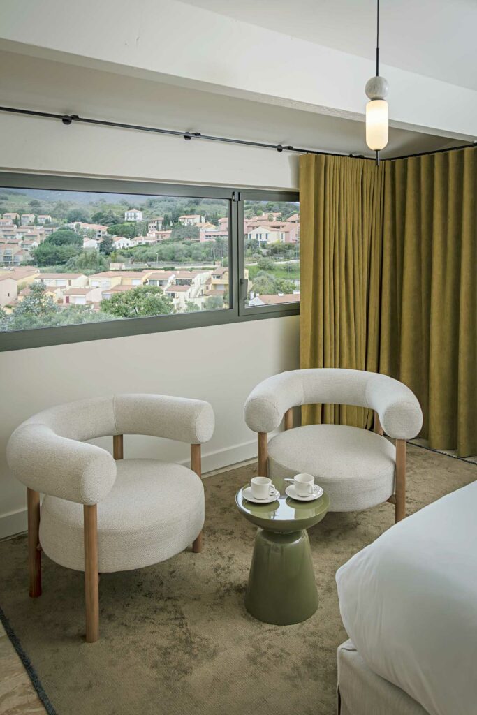 Chambre hôtel baie vitrée gris foncé coulissante, vue paysage méditerranéen