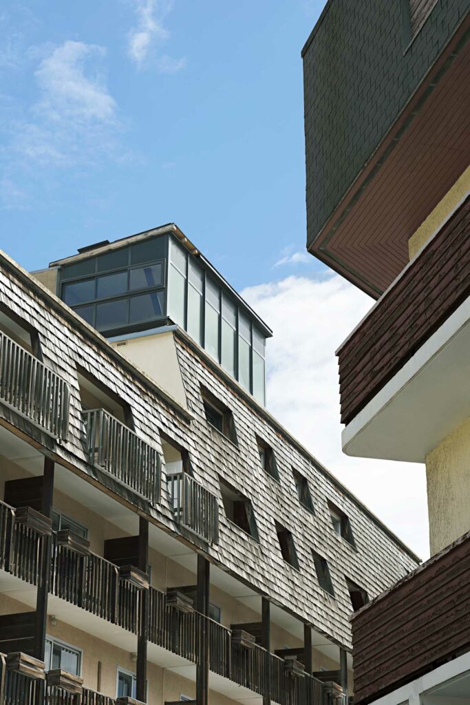 Extension véranda contemporaine adjacent bâtiment traditionnel, menuiserie aluminium et brique, balcons terrasse