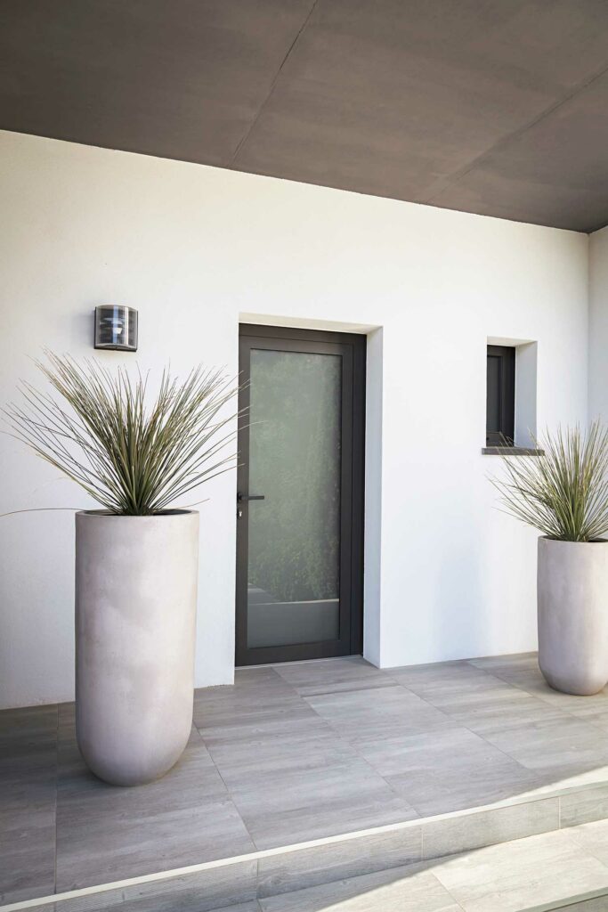 Porte d'entrée contemporaine aluminium noir, vitre dépoli, maison blanche minimaliste, sécurité design