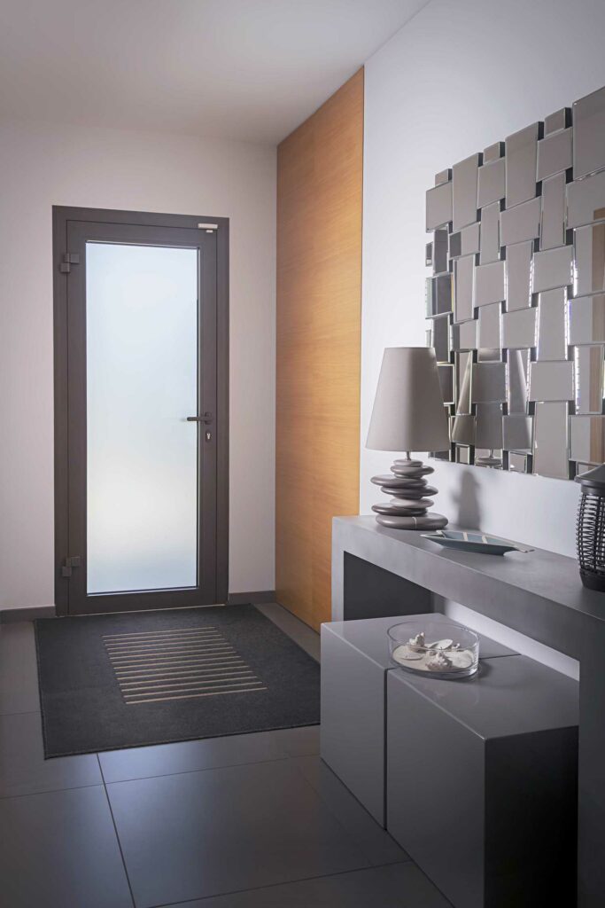 Porte intérieure couloir avec vitrage blanc opaque, menuiserie gris foncé, hallway épuré