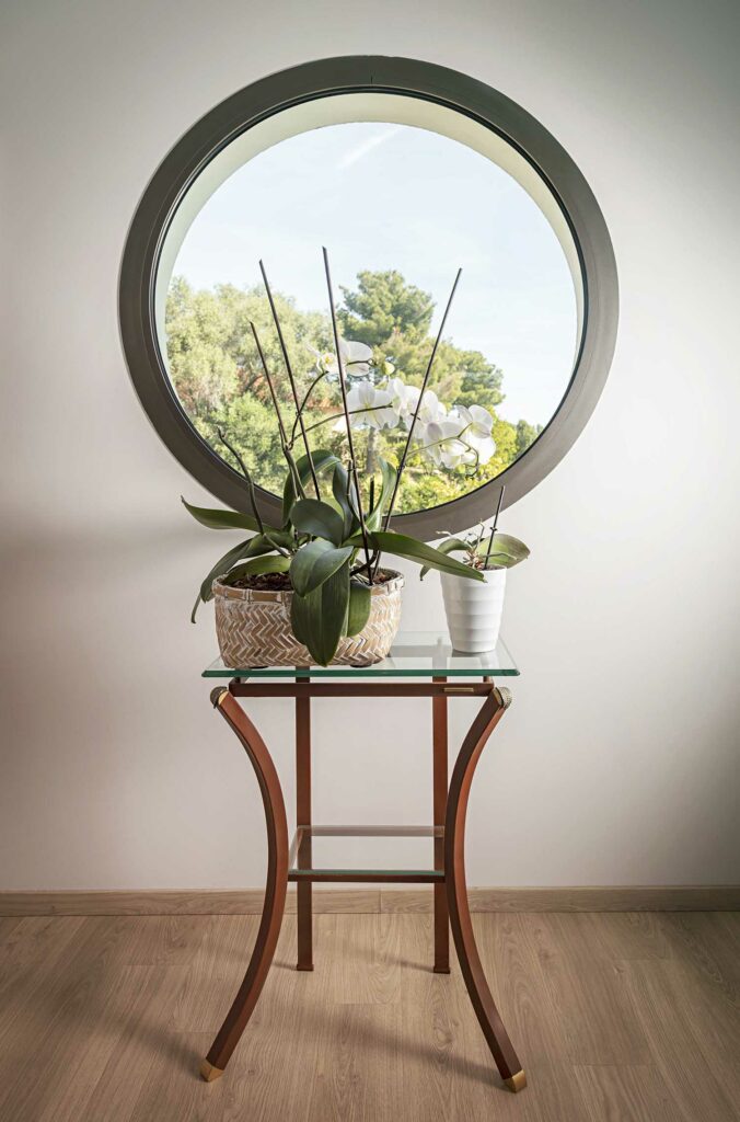 Fenêtre circulaire ronde gris foncé, vue jardin nature, décoration minimaliste, design unique