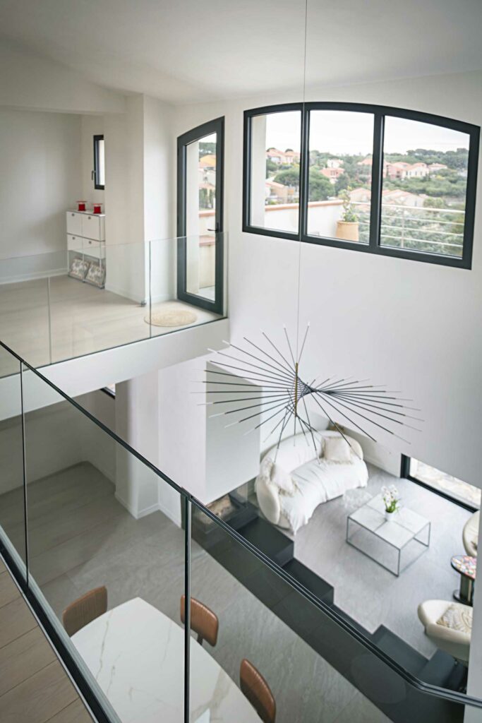 Mezzanine garde-corps verre hauteur étage, vue paysage, fenêtres cintrées noires, intérieur lumineux