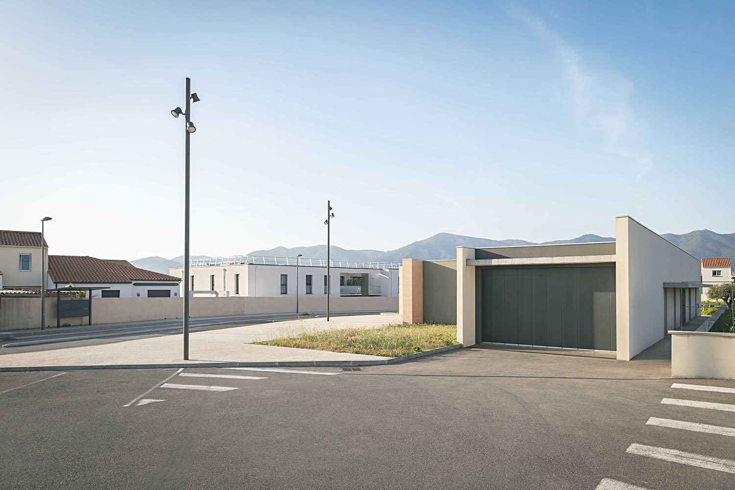 Portail garage double battant aluminium gris, colonnes support béton, paysage montagne