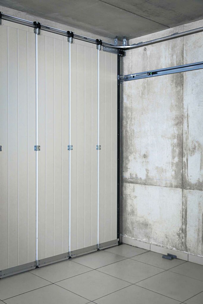 Porte de garage accordéon pliante blanche, système motorisé rails, intérieur garage