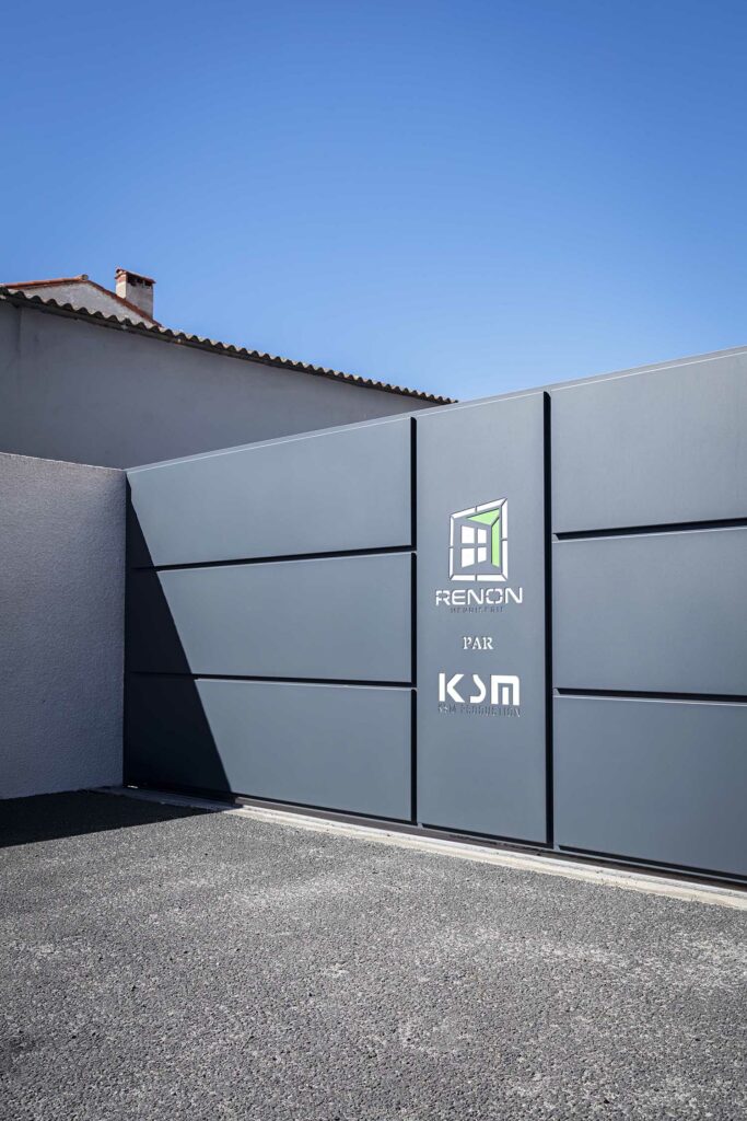 Porte motorisée siège Renon, panneaux gris lames horizontales, design moderne épuré, signalétique entreprise KSM